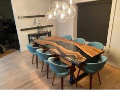 a dining room table with blue chairs and a large wooden slab on the center piece