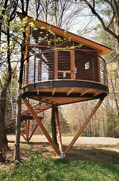 a tree house built in the woods on stilts for people to stay and play