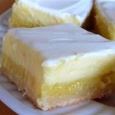 two pieces of yellow cake sitting on top of a white paper plate next to each other