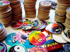 a table topped with lots of different colored plates and bowls covered in cartoon character stickers