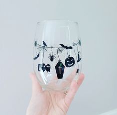 a hand holding up a wine glass decorated with halloween decorations