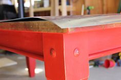 a red bench sitting inside of a garage