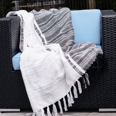 a black and white blanket sitting on top of a couch next to a blue chair