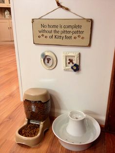 there is a dog food dispenser next to a bowl on the floor