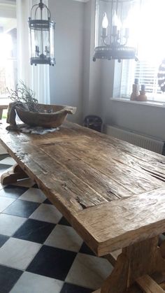 a large wooden table sitting on top of a checkered floor