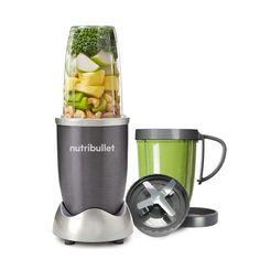 the nutribullet blender is next to a cup with vegetables in it