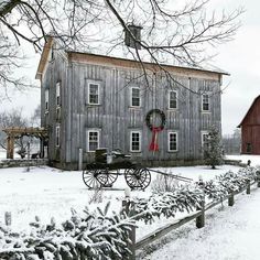 black and white photograph of an old farm house with a wagon in the front yard