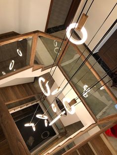 an overhead view of a staircase with glass railings and lights on the top floor