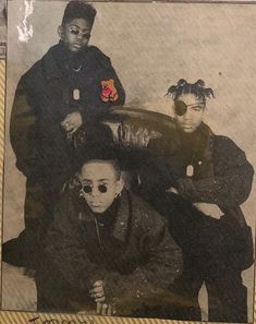 an old photo of three young men posing for the camera with one man wearing sunglasses