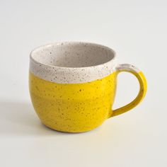 a yellow and white cup sitting on top of a table