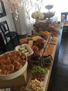 a buffet table filled with different types of snacks and desserts on wooden trays