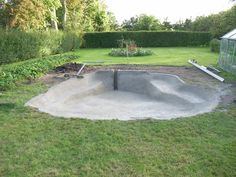 a concrete skateboard ramp in the middle of a yard