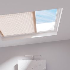 a bathroom with a skylight above it and a toilet in the corner next to it