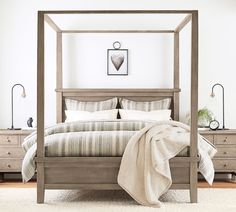 a four poster bed in a bedroom with white walls