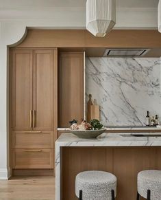 a kitchen with marble counter tops and stools