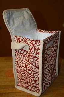 a red and white fabric storage bag on top of a wooden table