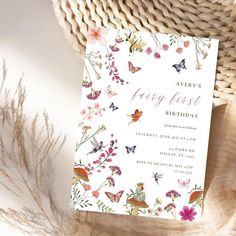 a birthday card sitting on top of a table next to a basket with flowers and butterflies