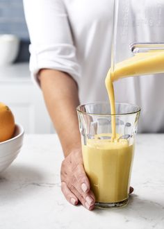 someone pouring orange cream into a blender with the words, deliciously delicious orange cremesicle smoothie gluten - free / vegan