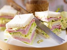 a cut in half sandwich sitting on top of a white plate next to a knife