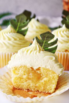 cupcakes with white frosting and green leaves on top