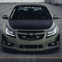 the front end of a silver car parked in a parking lot