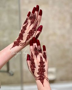 two hands with henna tattoos on them