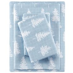 two blue place mats with white pine trees on them