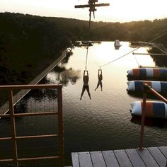 two people are suspended in the water by ropes