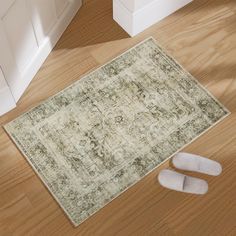 a pair of slippers sitting on top of a wooden floor next to a rug