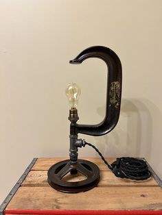 an old fashioned lamp is sitting on top of a wooden table with a light bulb attached to it