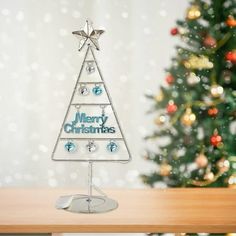 a glass christmas tree sitting on top of a wooden table