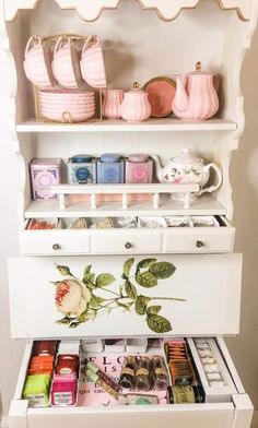 a white dresser with drawers filled with different items