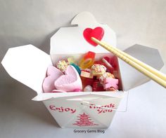 an open box with candy and chopsticks in it