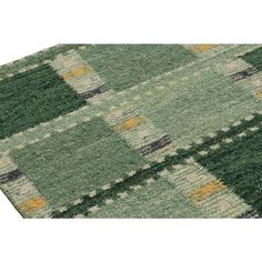 a green and yellow rug with squares on it