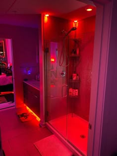 a bathroom with red lights on the shower