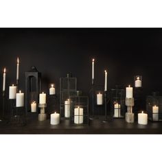 a group of lit candles sitting next to each other on top of a wooden table