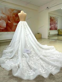 a white wedding dress on display in a room