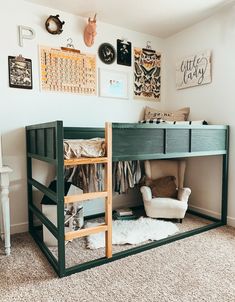 there is a bunk bed with a ladder in the corner and pictures on the wall above it