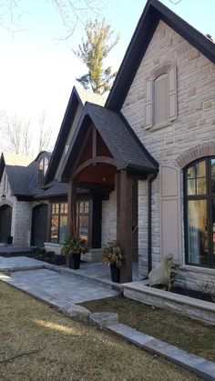 a house with two large windows and stone steps leading to the front door that lead up to it