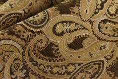 the fabric is brown and gold with an intricate pattern