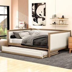 a white daybed with grey and beige pillows in a living room next to a window