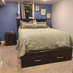 a bed sitting in a bedroom next to a dresser with drawers on top of it