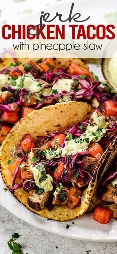 chicken tacos with pineapple slaw are served on a white plate and garnished with cilantro