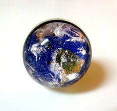 a marble ball with the earth in it's center on a white table top