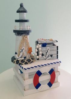 there is a small wooden box with a lighthouse on it and other items around it