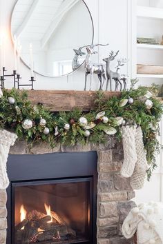 a fireplace decorated for christmas with stockings and ornaments