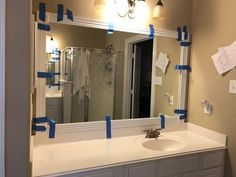 a bathroom mirror with blue tape taped around it