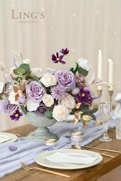 a vase filled with purple and white flowers on top of a table