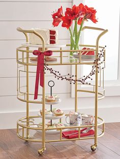 a gold serving cart with red flowers on top