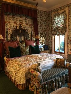 a large bed sitting in the middle of a bedroom next to a dresser and window